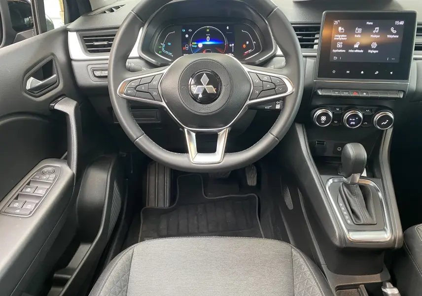 Intérieur du Mitsubishi ASX 2023, vue centrée sur le volant, tableau de bord digital et console avec boîte auto.