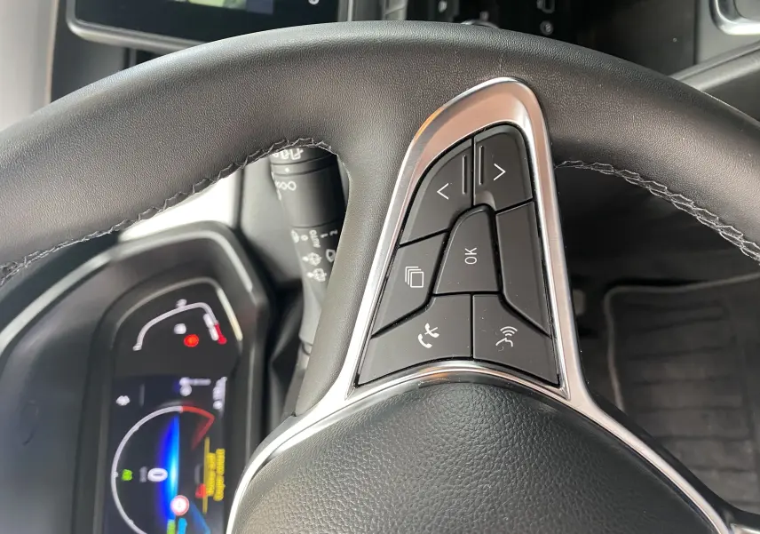 Gros plan sur le volant noir avec commandes multifonctions du Mitsubishi ASX 2023 hybride en intérieur.