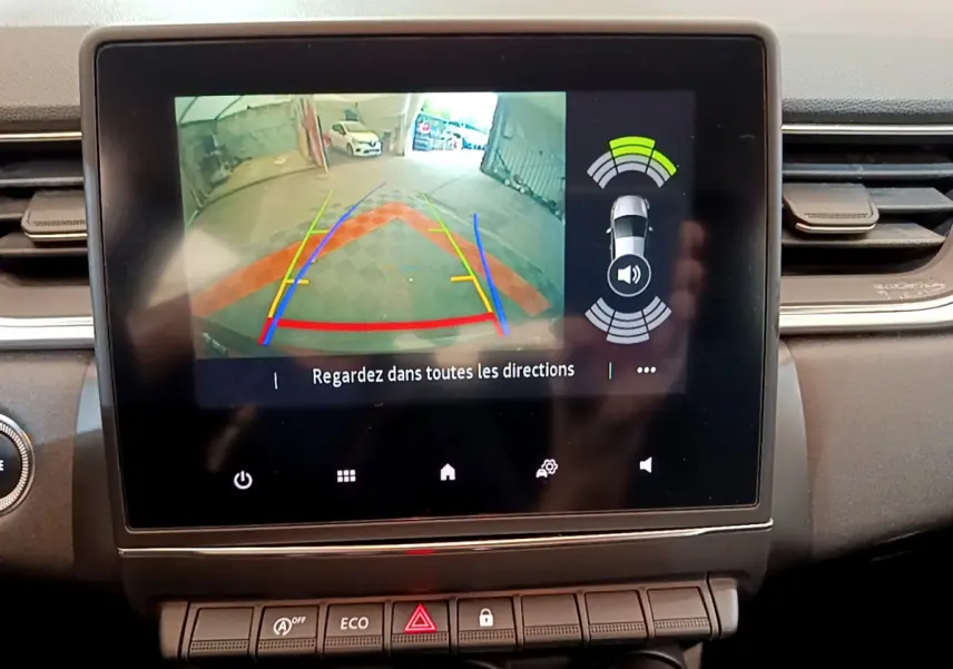 Écran tactile intérieur du Renault Captur noir montrant la caméra de recul avec guidage et capteurs de stationnement actifs.