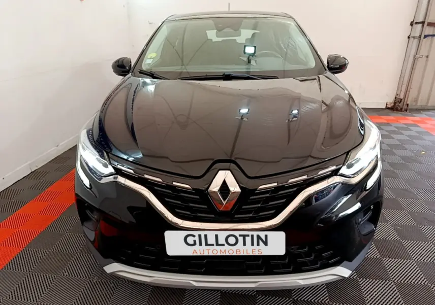 Vue frontale d'un Renault Captur noir 2020 avec calandre chromée et phares LED allumés en intérieur showroom.
