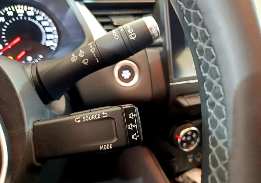 Gros plan sur les commandes au volant et bouton démarrage d'un Renault Captur noir, version Business Blue dCi 95.