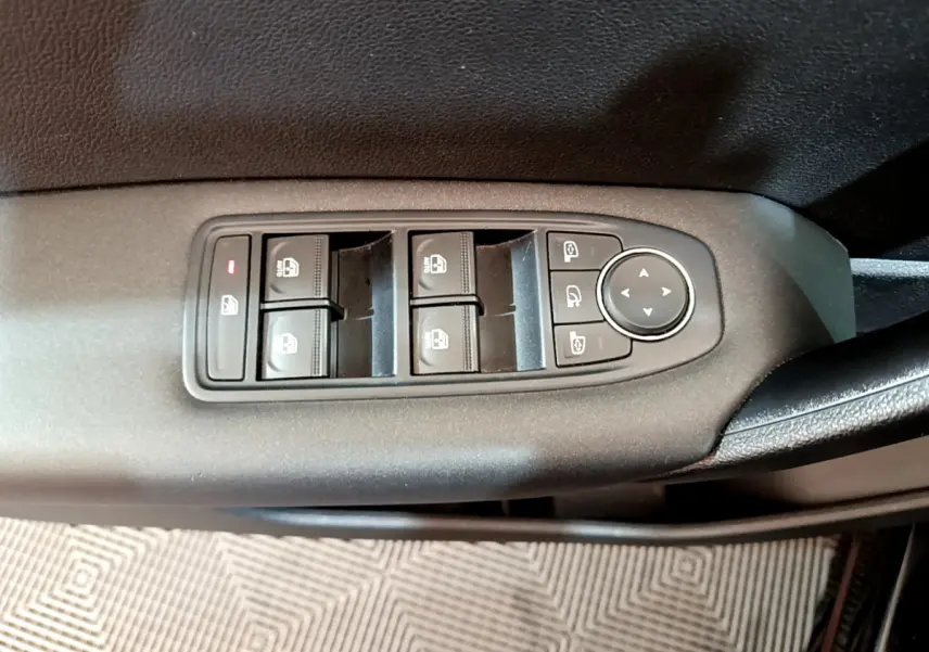 Gros plan sur les commandes de lève-vitres et rétroviseurs côté conducteur d'un Renault Captur noir 2020.