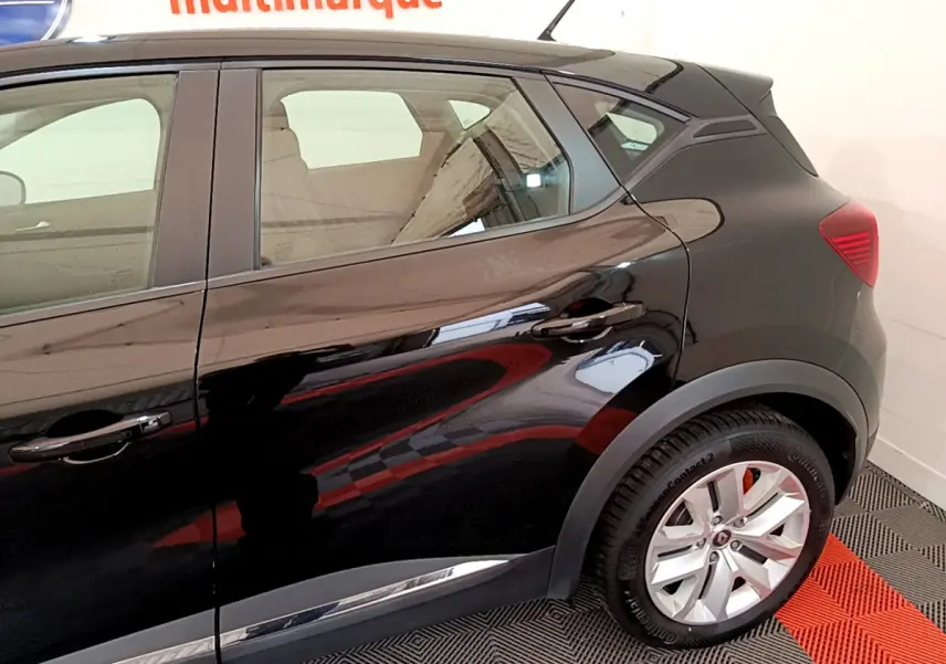 Vue côté droit arrière du Renault Captur noir 2020 avec jantes argentées et poignées de porte ton caisse.