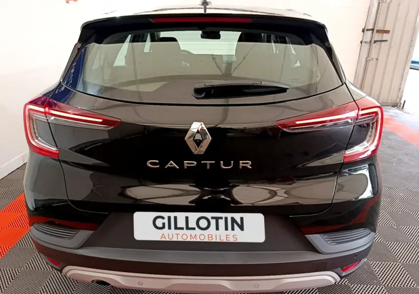Vue arrière d'un Renault Captur Business noir avec feux LED allumés dans un garage lumineux.