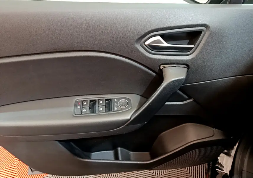 Vue intérieure côté gauche de la porte noire du Renault Captur 2020 avec commandes électriques des vitres et poignée intégrée.