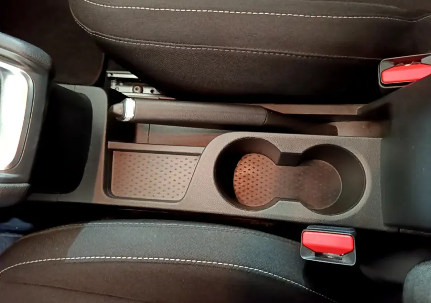 Vue plongeante sur la console centrale noire du Renault Captur 2020, avec frein à main manuel et porte-gobelets.