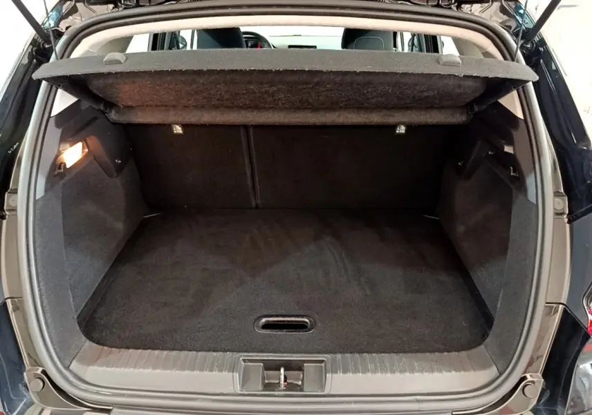 Coffre ouvert d'un Renault Captur noir 2020, vue arrière montrant l'espace de chargement vide et la tablette cache-bagages relevée.