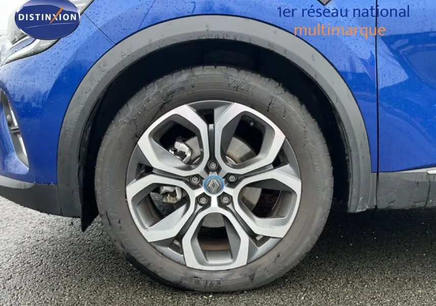 Vue latérale gauche du Renault Captur bleu iron metal avec toit noir, mettant en valeur l'aile avant et la roue.