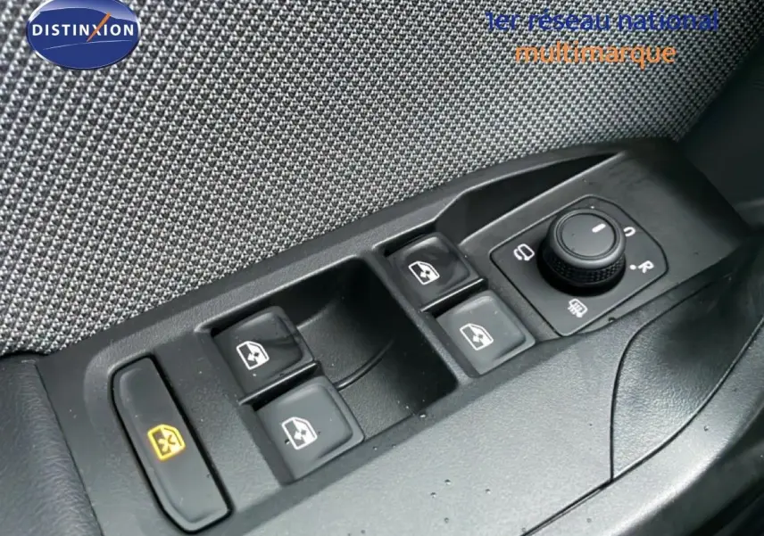 Gros plan sur les commandes de lève-vitres et réglage des rétroviseurs côté conducteur d’un SEAT LEON ST bleu Fjord.