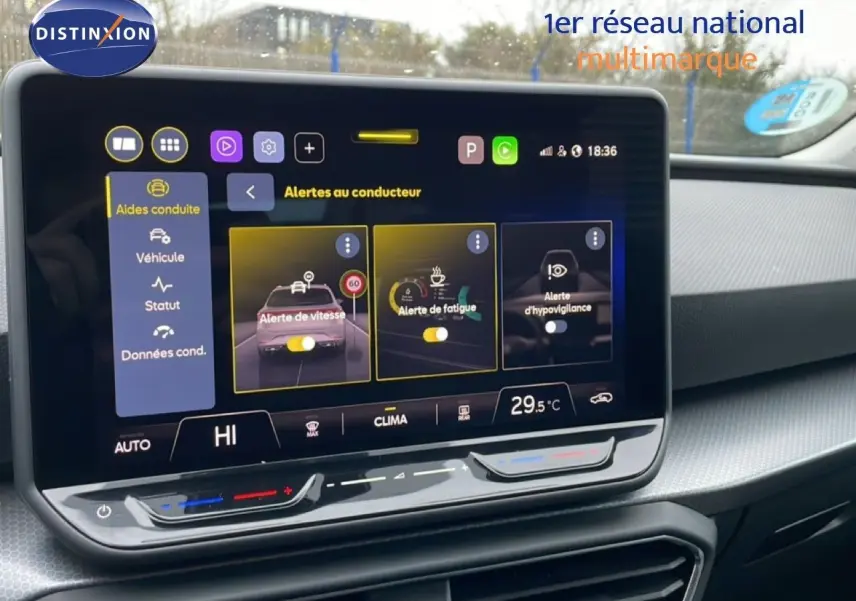 Écran tactile central du tableau de bord du SEAT LEON ST bleu Fjord, affichant les alertes au conducteur.