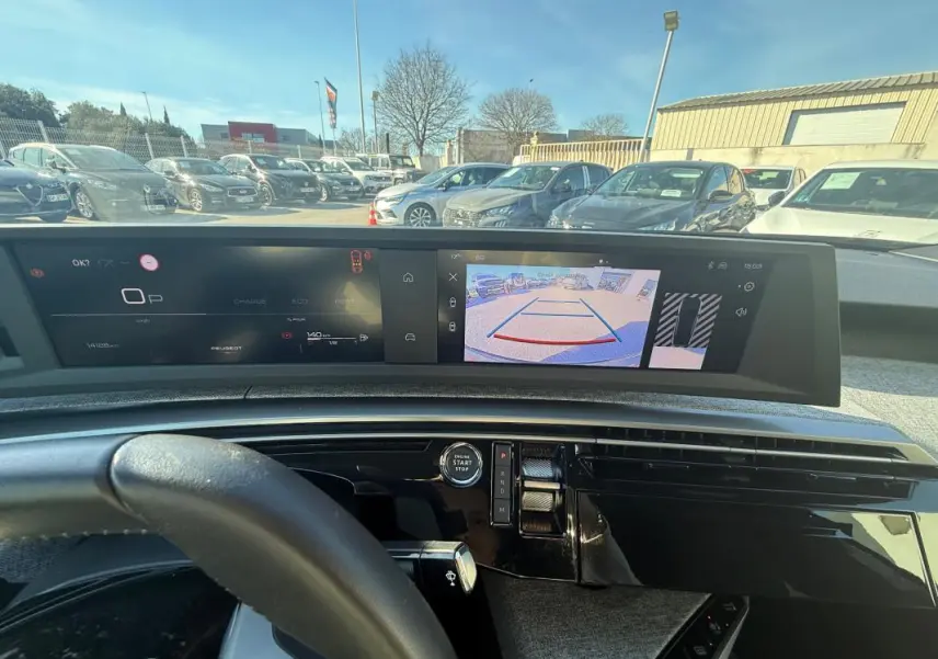 Vue intérieure du cockpit numérique du Peugeot 3008 Hybrid 145 Allure 2025, avec affichage caméra de recul et volant partiel.