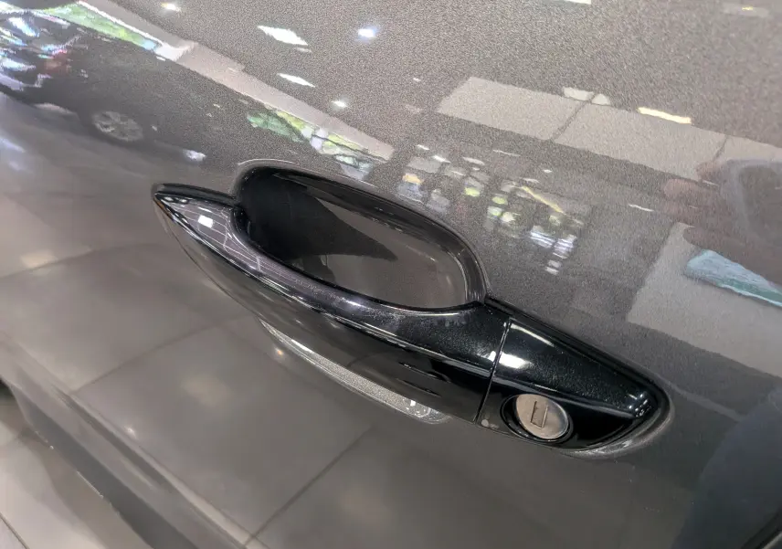 Poignée de porte noire en gros plan sur la porte gris Platinium d'un Citroën C5 Aircross hybride 2025.