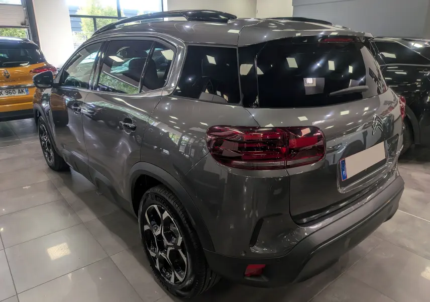 Citroën C5 Aircross hybride gris Platinium en 3/4 arrière droit, avec toit noir et jantes bi-ton noires.