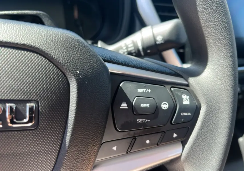 Gros plan sur le volant multifonctions noir de l'Isuzu D-MAX 2026 avec commandes de régulateur de vitesse.