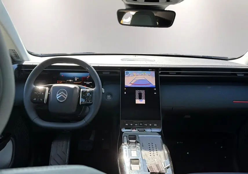 Intérieur du Citroën C5 Aircross hybride 2026 vu de face, volant multifonction et écran tactile central allumé.