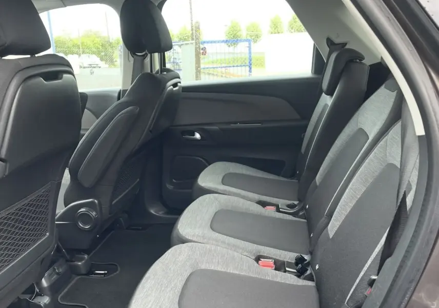 Vue intérieure côté droit des trois sièges individuels arrière gris et noir du Citroën C4 Picasso marron, avec porte ouverte.