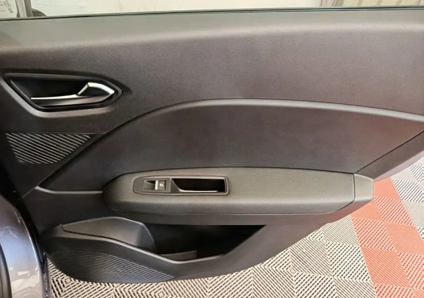 Vue côté gauche de la porte intérieure noire du Renault Captur 2025 avec poignée et commande de vitre électrique.