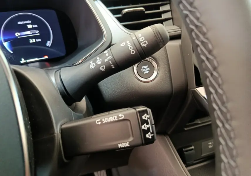 Détail du tableau de bord côté gauche du Renault Captur 2025 avec bouton start/stop et commandes au volant visibles.