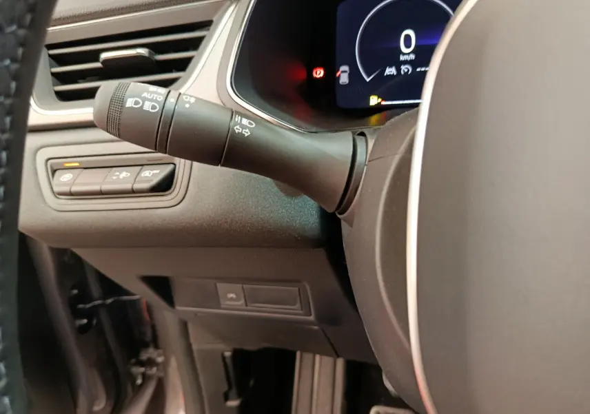 Gros plan sur la commande des phares et clignotants à gauche du volant du Renault Captur gris foncé 2025.