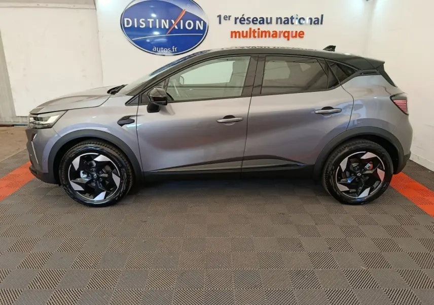 Profil côté gauche du Renault Captur gris foncé 2025 avec jantes noires et logo Distinxion en arrière-plan.