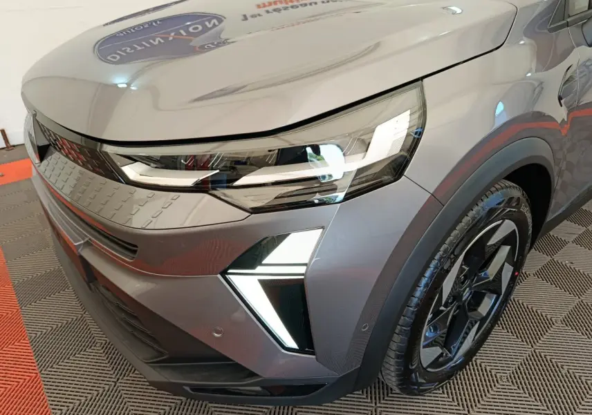 Gros plan sur l'avant droit du Renault Captur gris foncé 2025 avec phares LED et jante noire au design moderne.