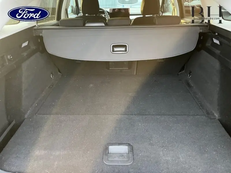 Vue intérieure du coffre spacieux d'une Ford Focus SW 2024 noir Agate métallisé avec cache-bagages déployé.