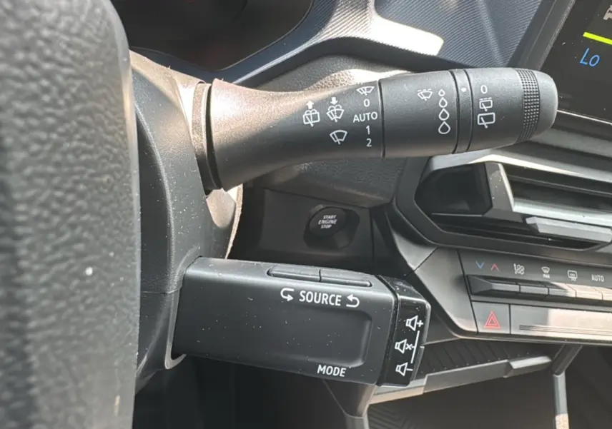 Détail du commodo gauche avec commandes audio et essuie-glace sur le tableau de bord du Dacia Duster 2025.