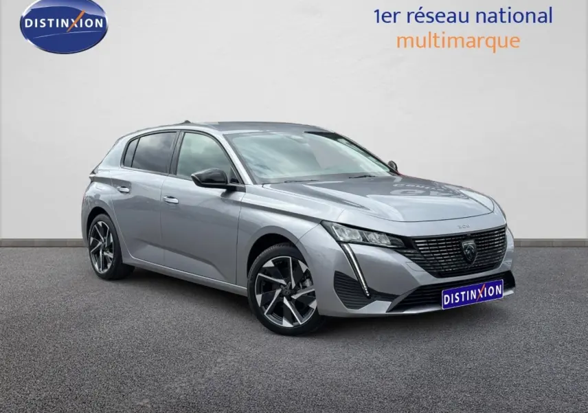 Peugeot 308 gris Artense vue 3/4 avant droit, avec calandre noire et jantes alliage distinctives.
