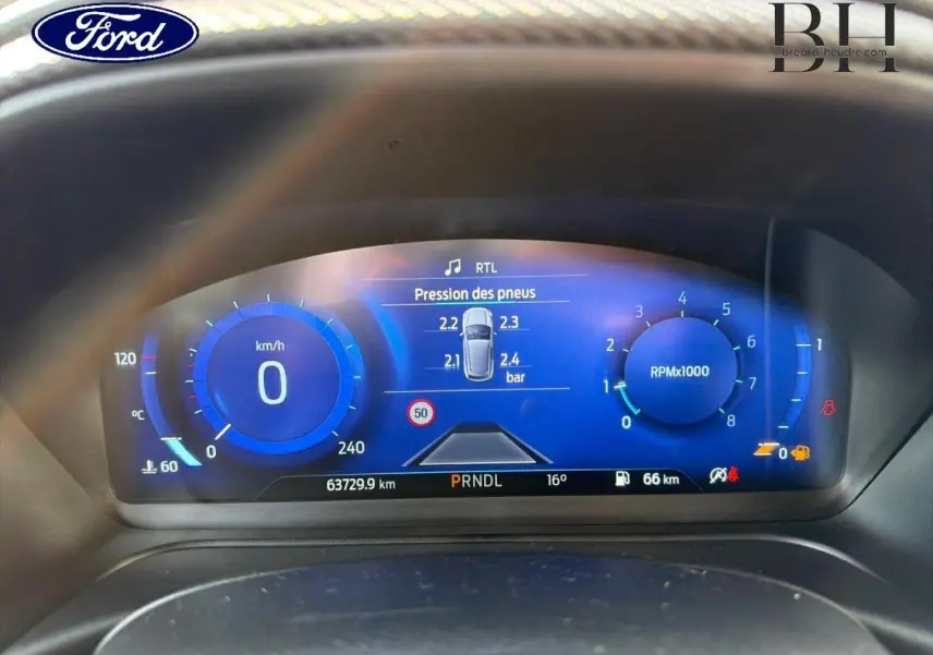 Tableau de bord numérique du Ford Puma 2023 montrant la pression des pneus et compte-tours en bleu lumineux.