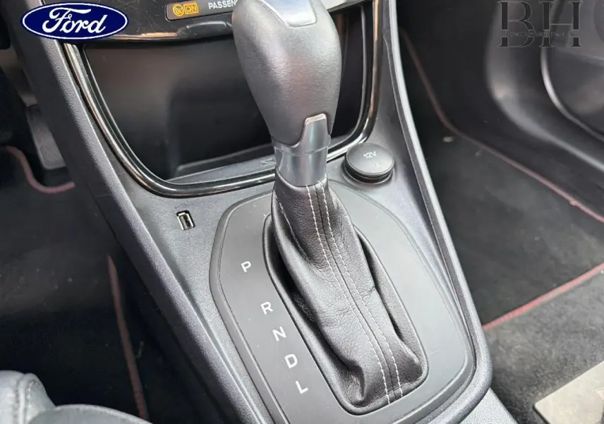 Gros plan sur la commande de boîte automatique noire du Ford Puma 2023, mettant en valeur le levier de vitesses et ses coutures.