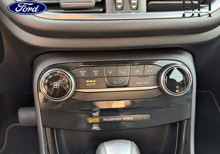 Gros plan sur la console centrale noire du Ford Puma 2023, montrant les commandes de climatisation et la boîte automatique.