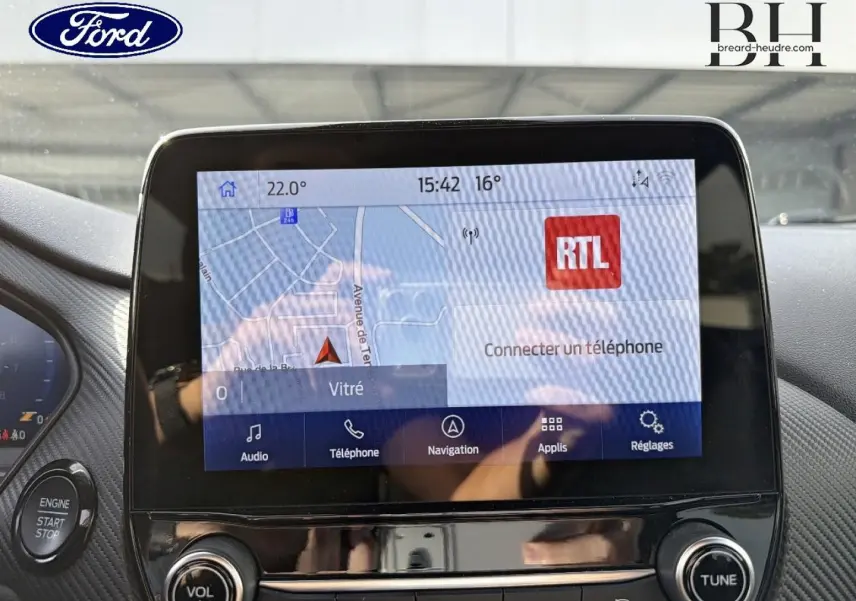 Écran tactile central du Ford Puma 2023 affichant la navigation et les options multimédia, avec bouton start/stop visible.
