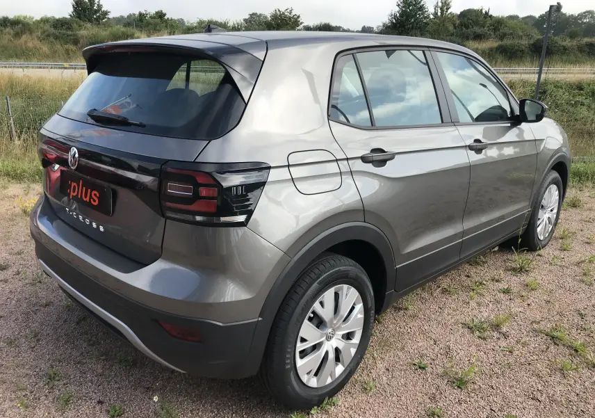 Vue 3/4 arrière droite du Volkswagen T-Cross 2020 gris limestone avec feux arrière noirs et jantes alliage.