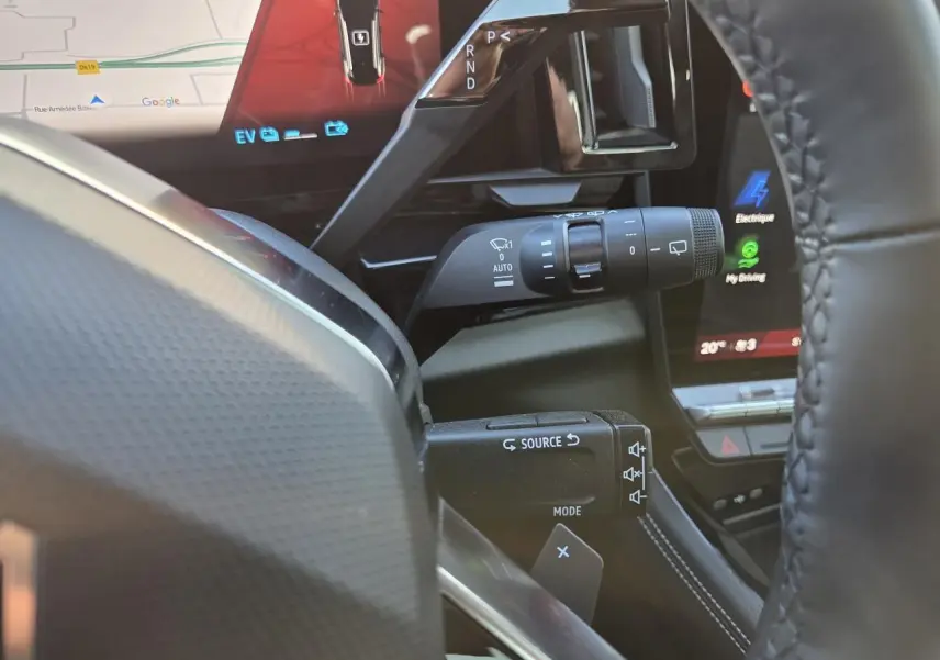 Vue rapprochée du volant et des commandes du Renault Austral E-Tech blanc nacré avec écran tactile et levier de vitesses.