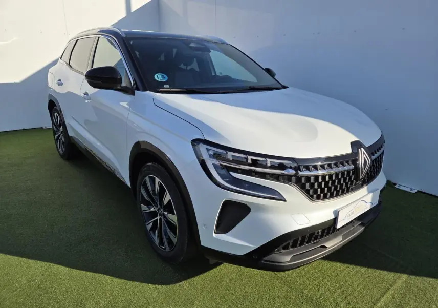 Renault Austral E-Tech blanc nacré avec toit noir, vue 3/4 avant mettant en valeur la calandre et les jantes noires.