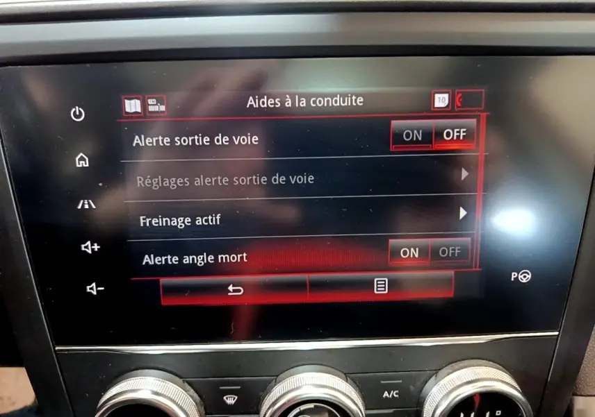 Écran tactile central du Renault Kadjar Rouge 2019 affichant les aides à la conduite, avec commandes climatisation en dessous.