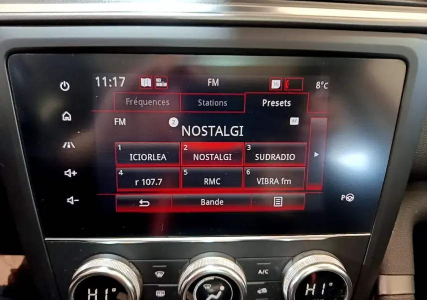Écran tactile central affichant les stations radio FM dans un Renault Kadjar rouge, vue intérieure frontale.