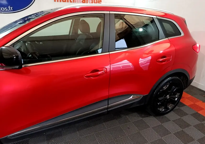 Profil côté gauche du Renault Kadjar SL Black Edition rouge, soulignant les jantes noires et la ligne de caisse chromée.