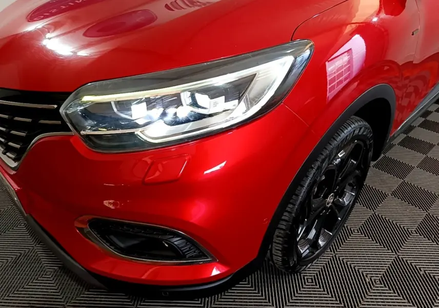 Gros plan sur l'avant droit rouge brillant du Renault Kadjar SL Black Edition avec phare LED et jante noire.