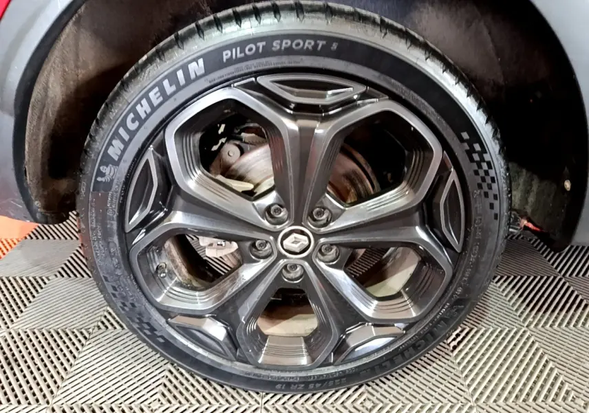 Gros plan sur la roue arrière droite du Renault Kadjar rouge, montrant le pneu et l'arche de roue intérieure.