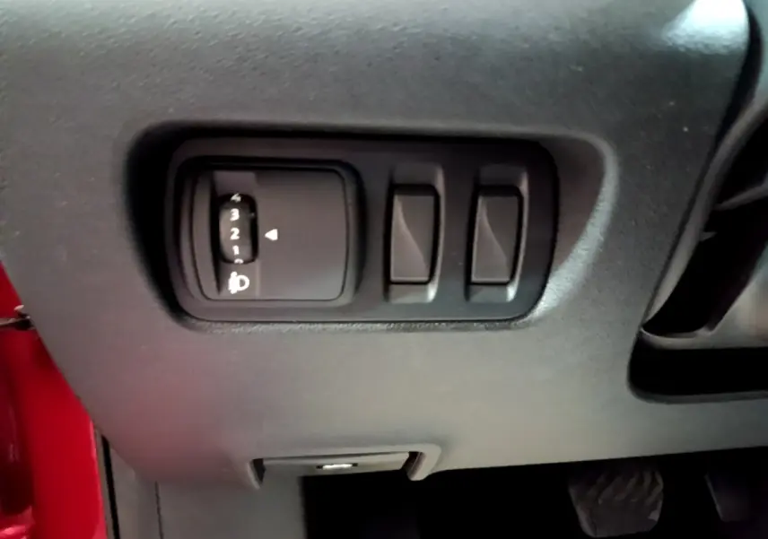 Détail du tableau de bord côté gauche avec commandes de réglage des phares sur Renault Kadjar rouge 2019.
