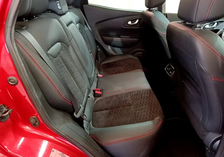 Vue intérieure arrière gauche du Renault Kadjar rouge, sièges noirs avec surpiqûres rouges et tissu matelassé.