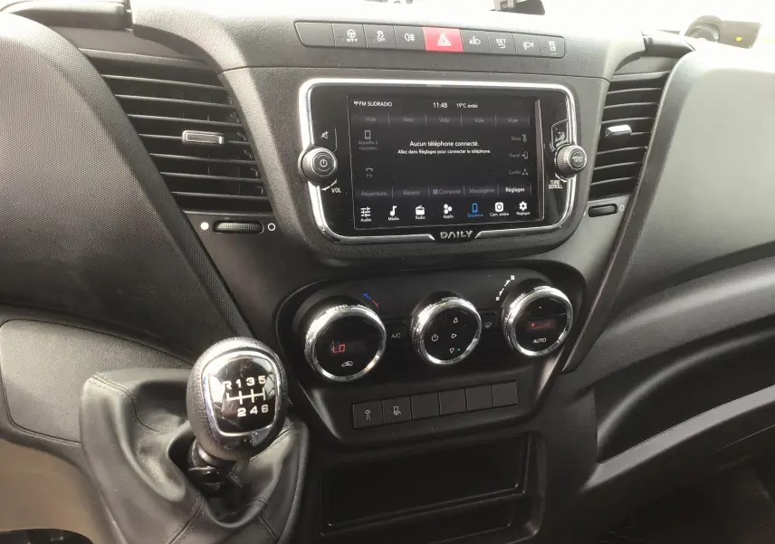Intérieur du tableau de bord du Iveco Daily 2022, avec boîte manuelle et écran tactile central affichant les réglages.