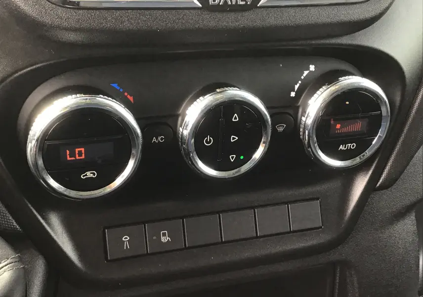 Gros plan sur les commandes de climatisation du tableau de bord du fourgon Iveco Daily blanc de 2022.