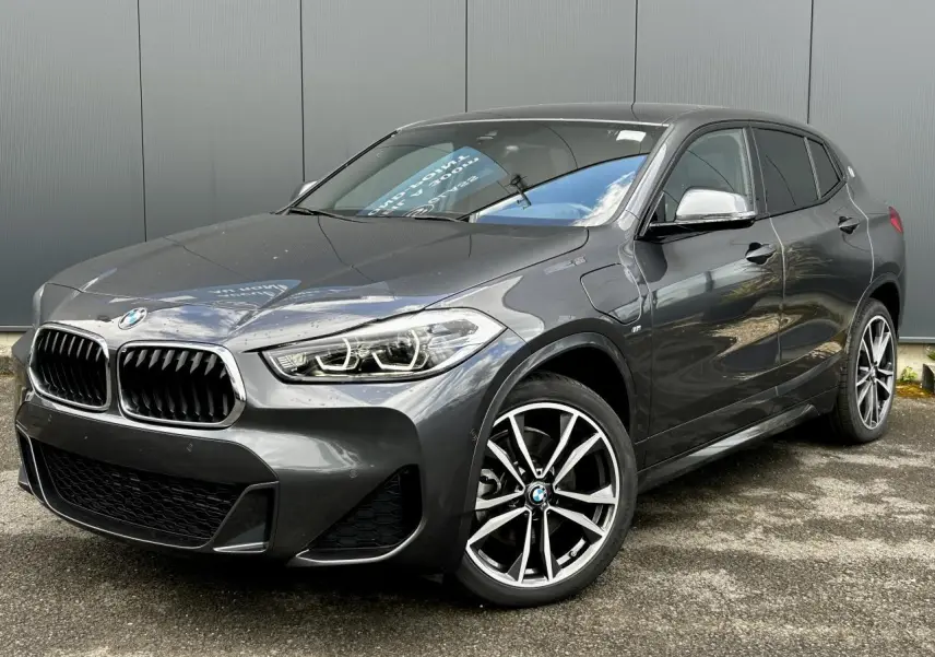 BMW X2 gris minéral en vue 3/4 avant droit avec jantes alliage bicolores et calandre M Sport distinctive.