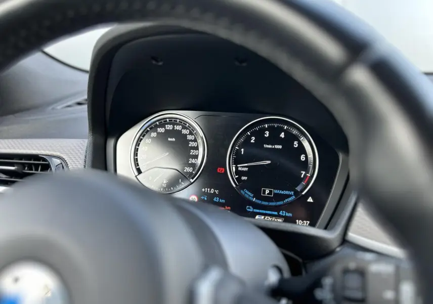 Vue depuis le volant sur le tableau de bord numérique du BMW X2 gris Mineral, affichant vitesse et compte-tours.