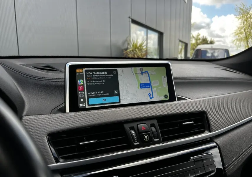 Vue du tableau de bord du BMW X2 gris Mineral 2021 avec écran GPS et finition M Sport visible depuis le siège conducteur.