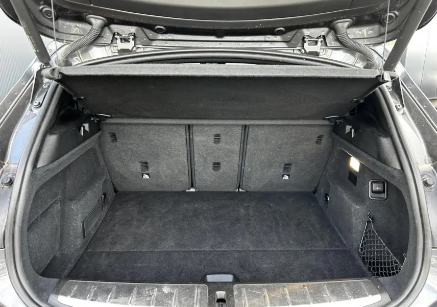 Coffre ouvert d'une BMW X2 F39 gris Mineral, montrant un espace de chargement propre et bien agencé.