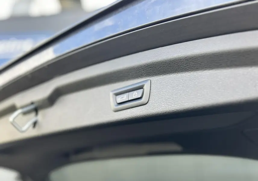 Bouton de fermeture électrique du hayon sur BMW X2 gris Mineral, vue rapprochée du hayon ouvert.