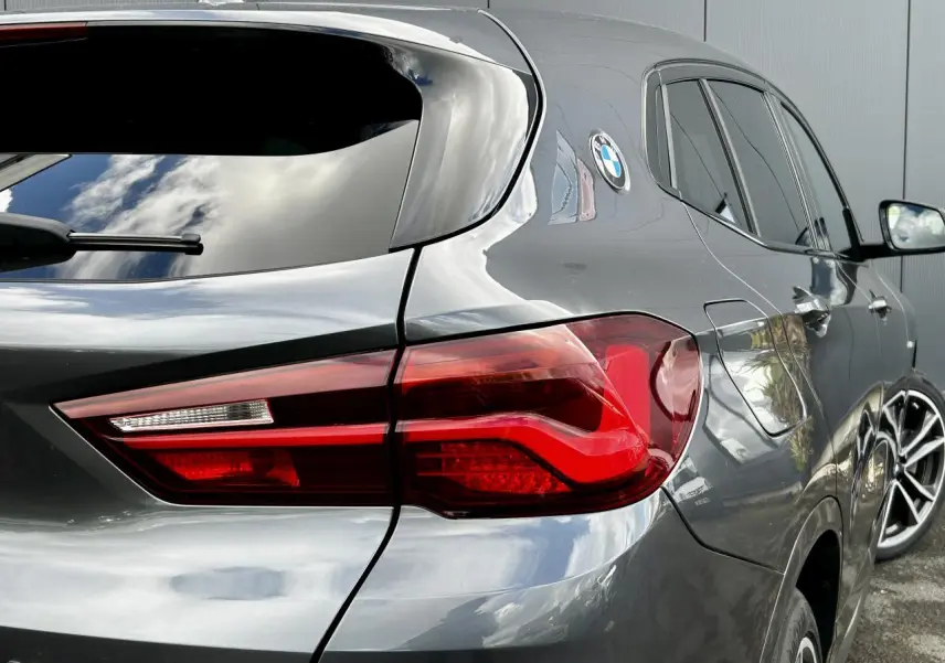 Gros plan sur l'arrière droit d'un BMW X2 gris Mineral avec feux arrière LED et jantes alliage bicolores.